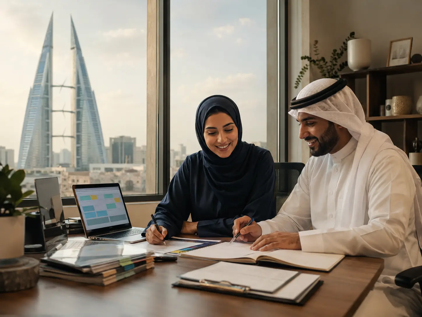 رجل وامرأة بحرينيان يعملان بهدوء على خطط وبيانات منظمة في مكتب مطل على البحرين